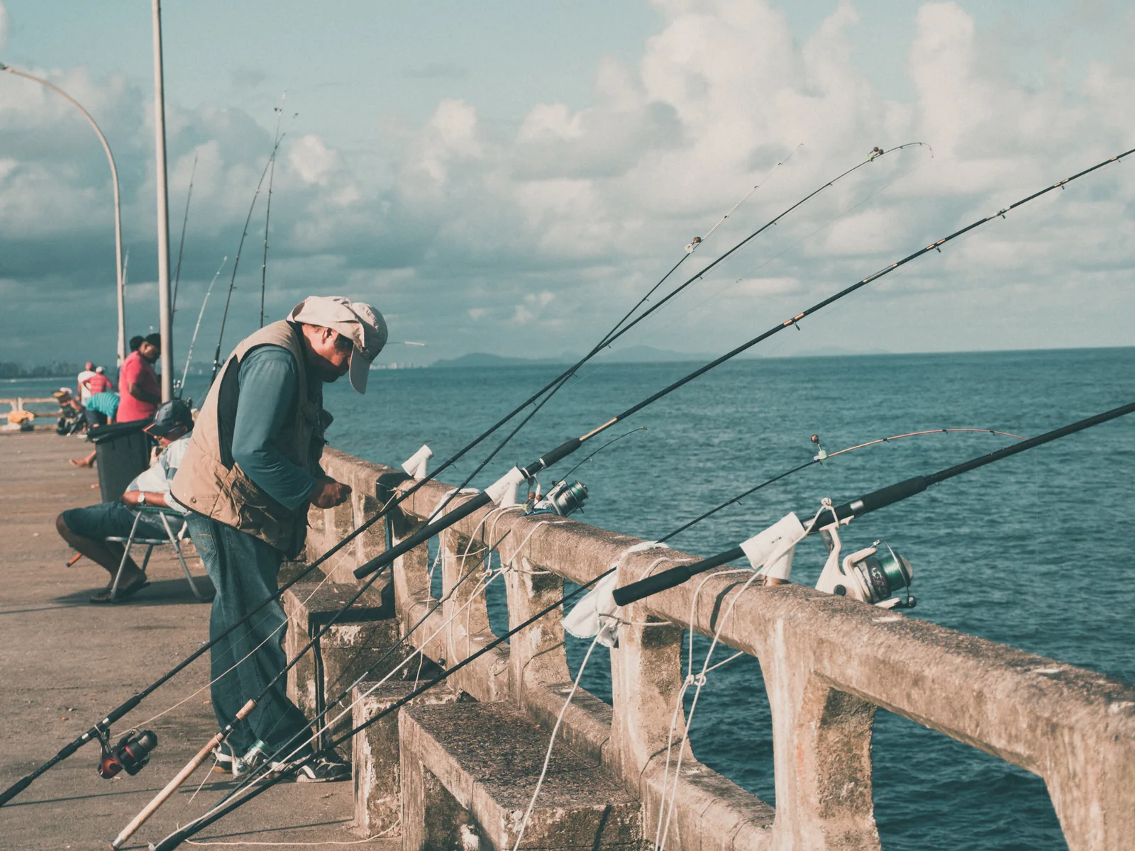 Pescadores practicando spinning desde un muelle al inicio de la jornada